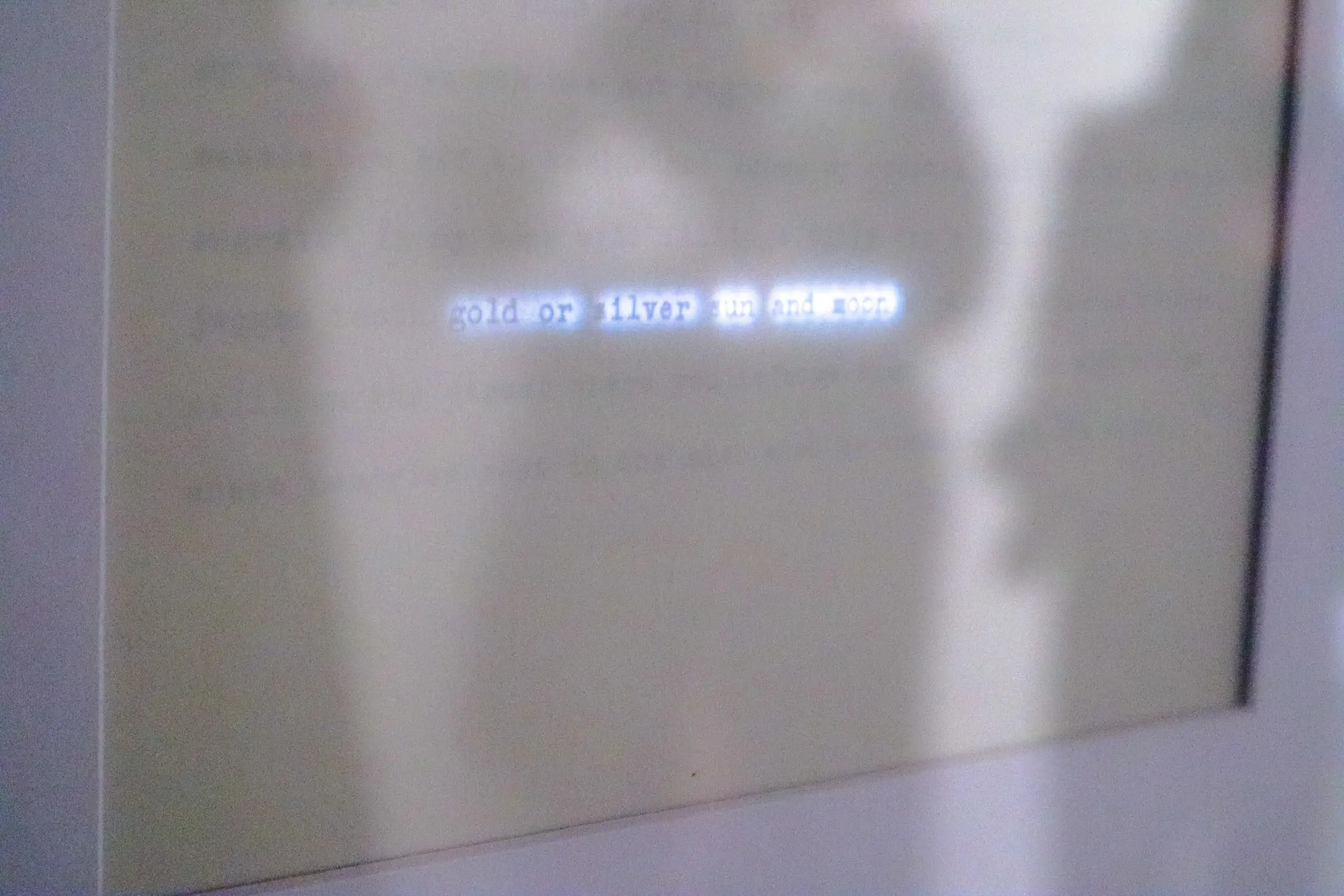 Paper poem lit from behind showing partial words