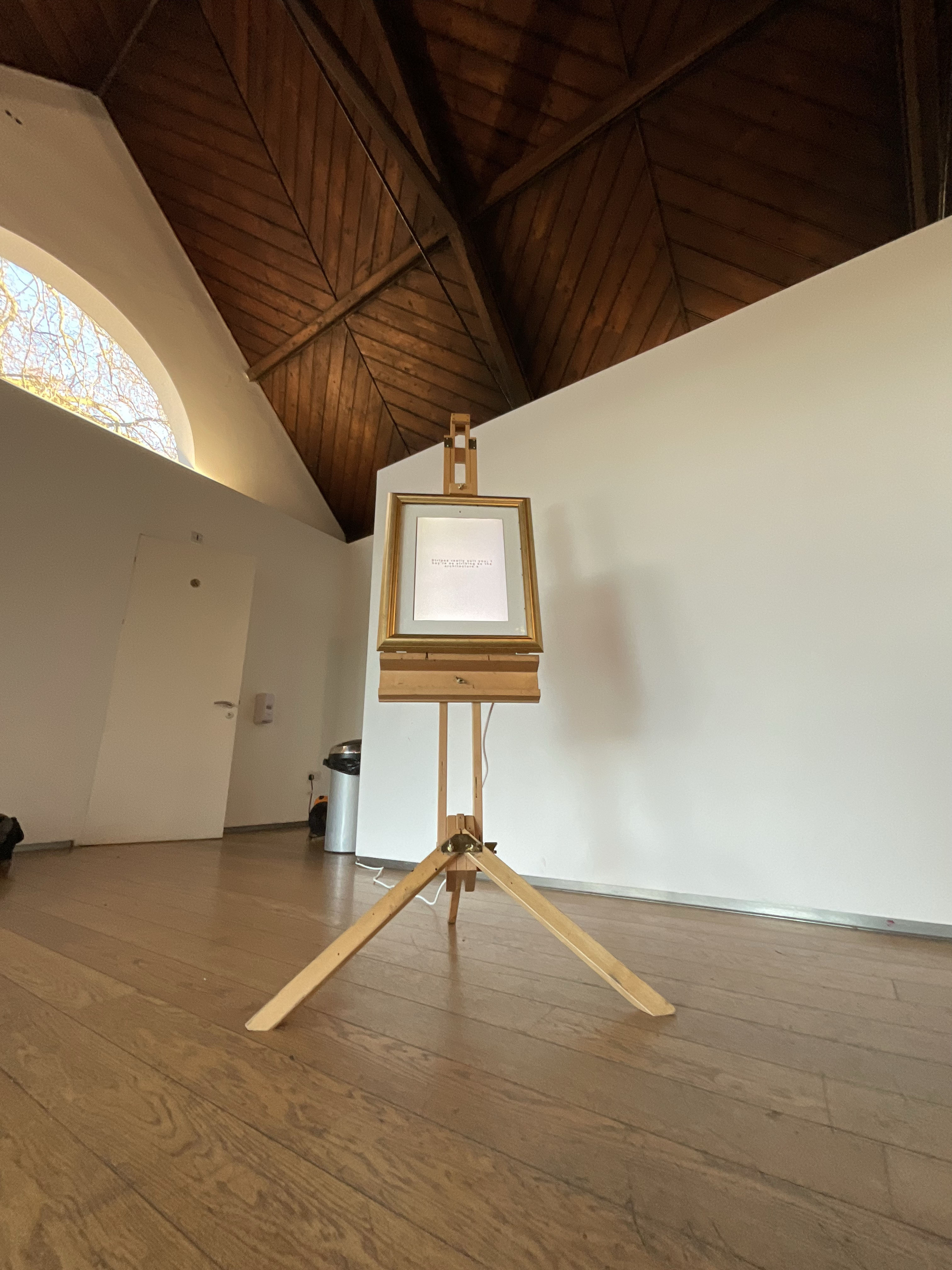 Text in a frame on a easel in a gallery space